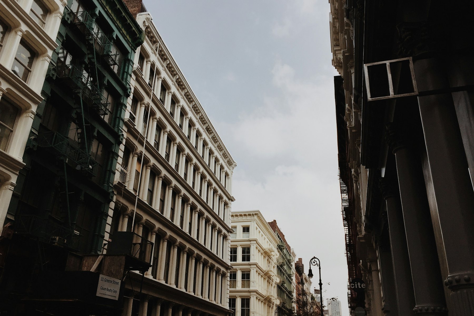 A brown stone building under a clear sky with white clouds